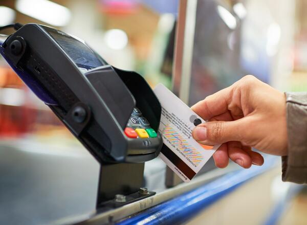 Person swiping credit card through a payment machine